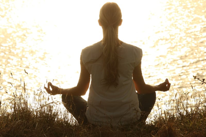 woman meditating at sunset